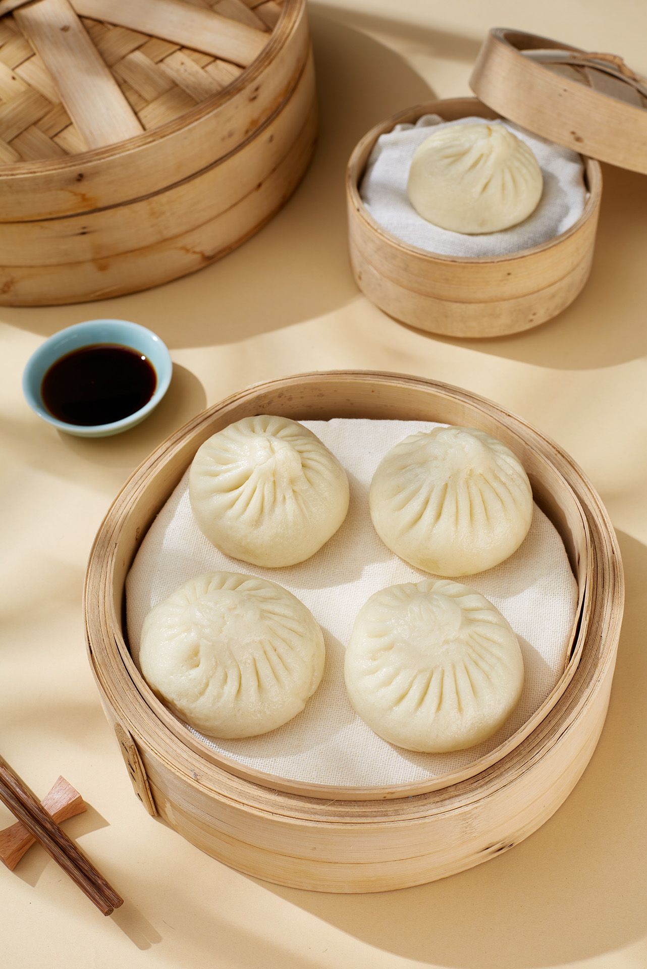 为包子食品品牌打造的电商产品摄影案例，通过蒸笼陈列、俯拍构图与包装同框画面，呈现产品的饱满质感、新鲜感和中式餐点氛围。图片可用于电商详情页、品牌宣传、菜单物料及社交媒体内容。